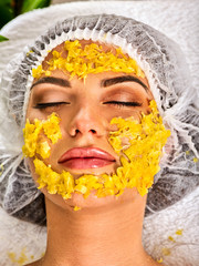 Facial mask from fresh fruits for woman. Girl in medical hat give slices of avocado, grapefruit and kiwi as ingradients for face care smooth skin on isolated. Girl at the spa salon.