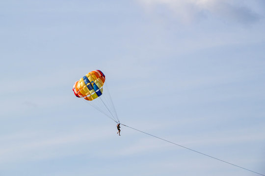 man parasailing on blue sky