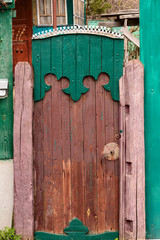 Old ancient wicket door with an old fence, rustic house
