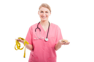 Nutritionist lady holding measuring tape and cookies