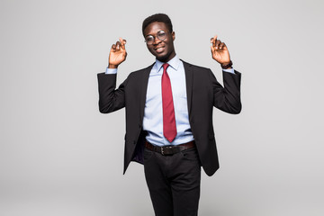 Closeup portrait young african, business man crossing fingers, wishing, hoping for best, miracle isolated black, grey background.