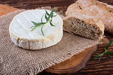 Camembert cheese in burlap  on wooden rustic background