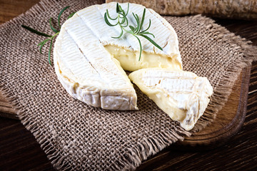 Camembert cheese in burlap  on wooden rustic background