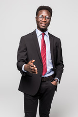 Young happy African businessman smiling while giving handshake on grey