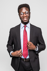 Studio fashion portrait of a handsome young African American businessman wearing a black suit and tie. Isolated on gray background