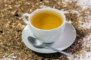 Cup of Tea. A hot white cup of tea on a saucer with a teaspoon.. A cup of tea on the table