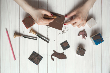 Handmade and creativity, closeup hands cut stamp - obrazy, fototapety, plakaty