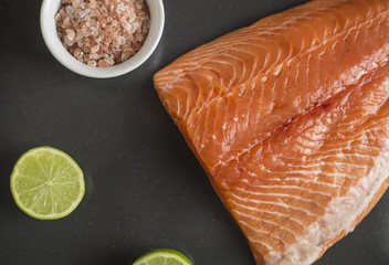 raw salmon fillets on dark background