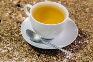 Cup of Tea. A hot white cup of tea on a saucer with a teaspoon.. A cup of tea on the table