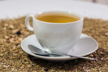 Cup of Tea. A hot white cup of tea on a saucer with a teaspoon.. A cup of tea on the table