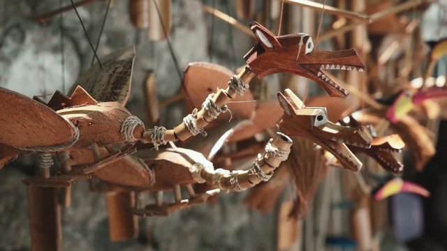 Wooden dragons toys on strings close up - street seller in Bali, Indonesia. Shot with Sony a7s on slider on sunny day