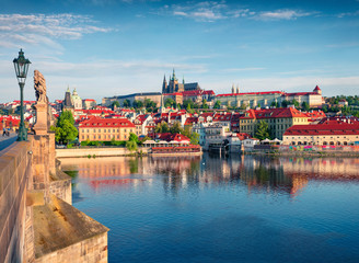Colorful morning view of Charles Bridge, Prague Castle and St. Vitus cathedral on Vltava river