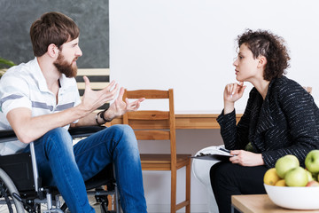 Therapist discussing with disabled patient