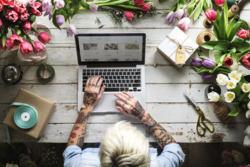 Woman Using Laptop Searching on Internet to Shop Flowers Plants Online