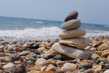 Fototapeta na wymiar Stack of stones on the rocky beach. Concept of balance and harmony at the sea