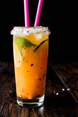 Mexican Michelada Cocktail with beer, lime, ice and spices..