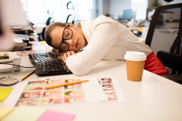 Tired businesswoman napping in creative office