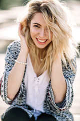 Blonde girl on the beach of the sandy beach by the sea