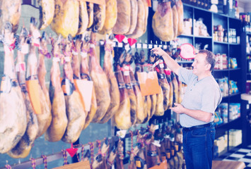 Fototapeta na wymiar Male client choosing Spanish jamon