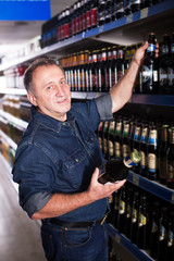 Pensioner selecting beer at store