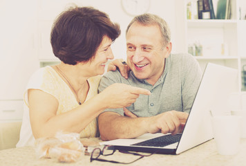 Mature man and woman looking at laptop