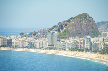 Bright scenic view of the golden crescent of Copacabana Beach with the city skyline of Rio de...