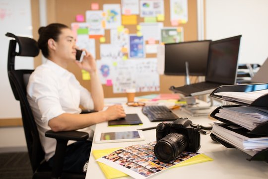 Designer talking on phone in creative office