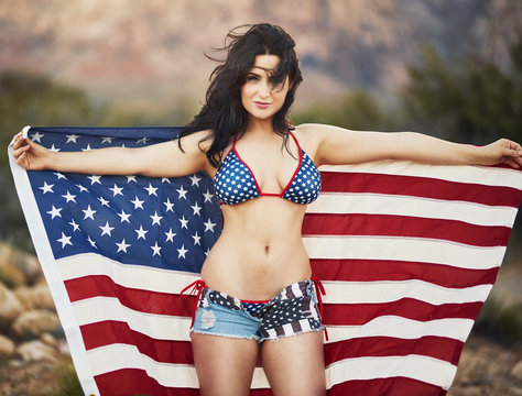 sexy patriotic woman holding american flag in desert