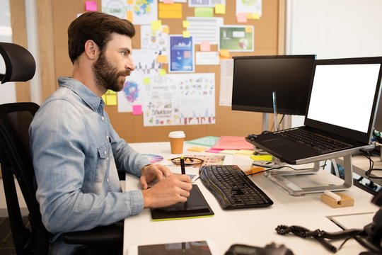 Designer using digitizer and stylus on creative office desk