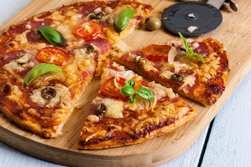 Slices of pizza with bacon, olives and tomatoes