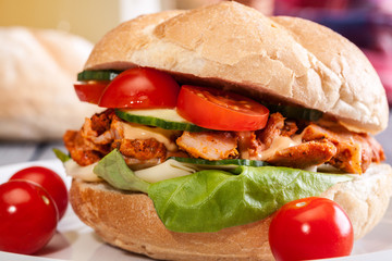Fried chicken meat with cheese and vegetables in bun