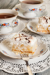 Fresh sweet apple cake with whipped cream served with cup of tea