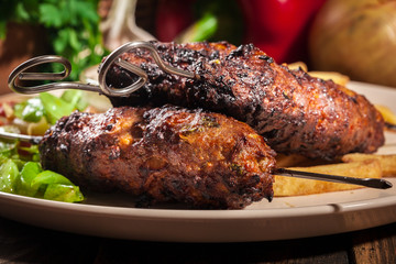 Grilled shish kebab served with fried chips and salad