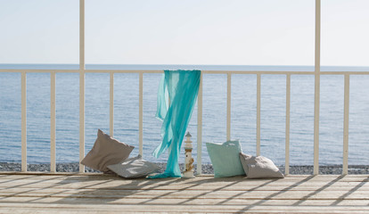 Cushions and a blue scarf on the background of the sea