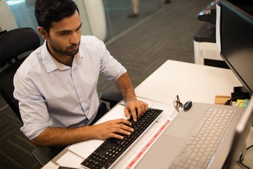 Businessman typing on keyboard at office desk