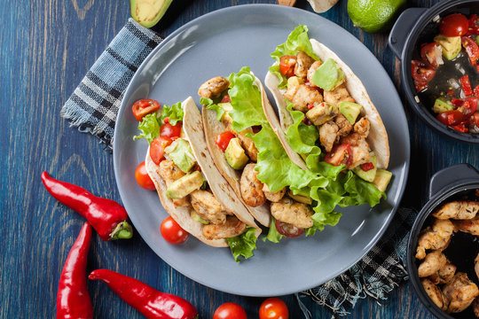 Authentic mexican tacos with chicken and salsa with avocado, tom