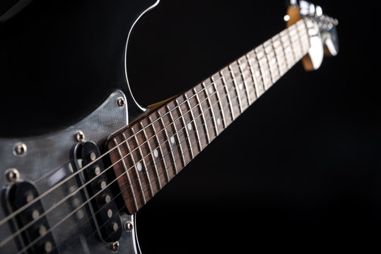 Music and art. Electric guitar on a black isolated background. Horizontal frame