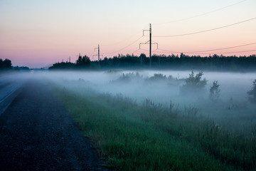 Fototapeta na wymiar Ground fog near the road at sunset