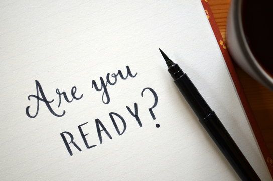 ARE YOU READY? written in notepad on desk with cup of coffee