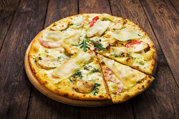 Delicious pizza with chicken, parmesan and fresh arugula