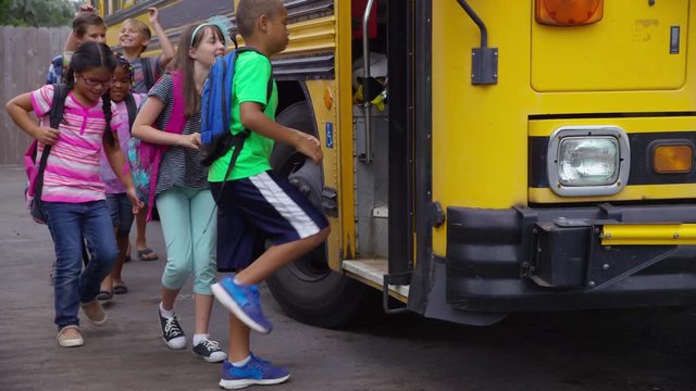 Students get onto school bus, slow motion