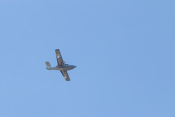 White passenger plane flies highly in the sky on a bright Sunny day without clouds