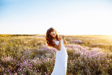 Young woman in wedding dress outdoors. beautiful bride in a field at sunset