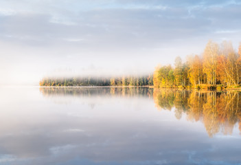Scenic landscape with lake and fall colors at morning light in Finland