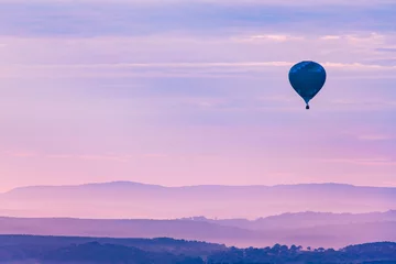 Foto op Canvas Heteluchtballon zweeft over de bergen in de schemering © DT Photography