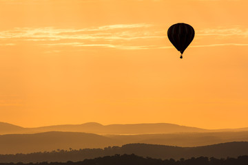 Obraz premium Hot Air Balloon Floating Over The Mountains In The Twilight