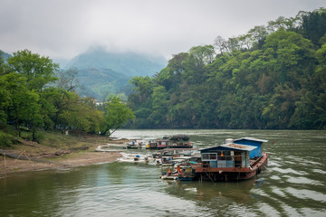 Fototapeta na wymiar de vieilles embarcations sur un fleuve en chine au milieu des montagnes de Guilin