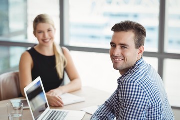 Portrait of smiling executives sitting at desk