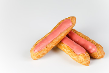 Pink icing Eclairs on white backgound 