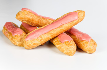 Pink icing Eclairs on white backgound 